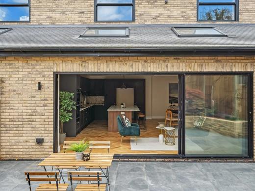 Brick rear extension with sliding doors open to a kitchen