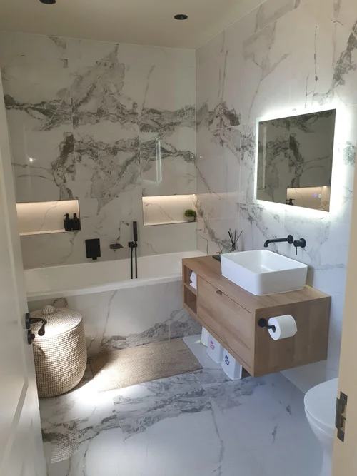 Bathroom with marble-effect tiles, floating oak vanity unit and backlit mirror