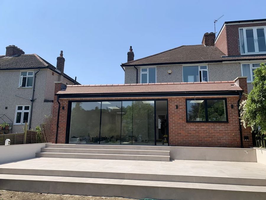 Single-storey rear extension with full-width sliding doors and stone patio steps