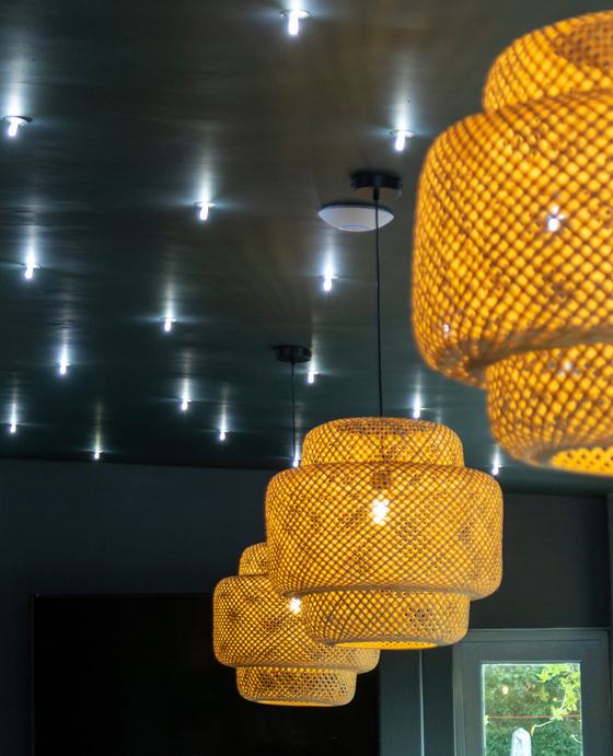 Dark ceiling with recessed spotlights and woven pendant shades