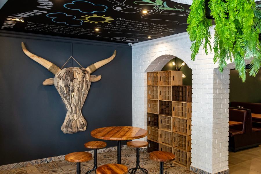 Seating area with a dark feature wall, white-painted brick arches and patterned floor tiles